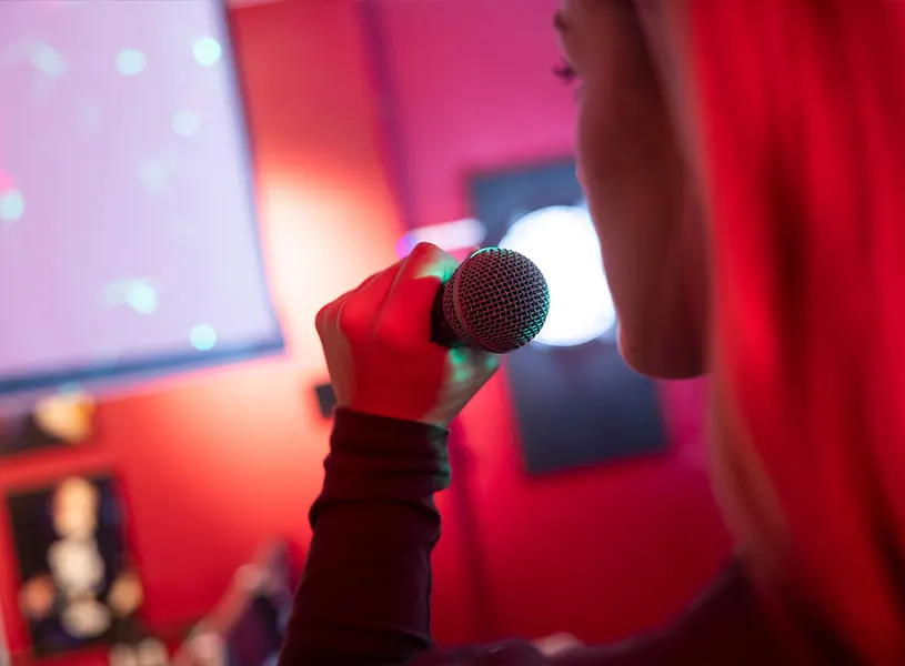 Frau singt Karaoke mit Mikrofon in der Beerpongbar Düsseldorf